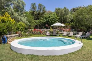 a pool in a yard with chairs and an umbrella at Villa Maria in Port de Pollensa