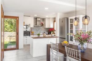 a kitchen with white cabinets and a table and chairs at Villa Maria in Port de Pollensa