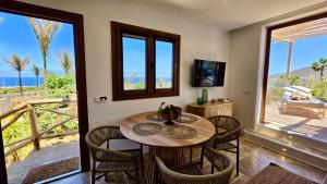 a dining room with a table and chairs and a balcony at Apartamentos Finca RiscoTierra in Arafo
