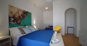 a bedroom with a blue bed in a room at Mapo Village Plaia in Villanova di Ostuni +45 photos
