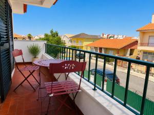 a balcony with a table and chairs and a street at Aomo-casa parede in Parede