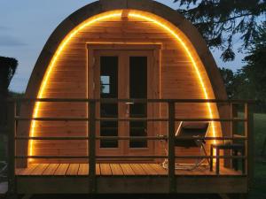 a round wooden cabin with an arched door on a deck at La Cabane MIMOSA in Saint-Malo-du-Bois