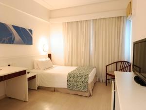 a hotel room with a bed and a television at Boulevard Plaza in Belo Horizonte
