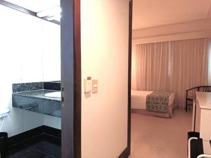 a room with a bathroom with a bed and a mirror at Boulevard Plaza in Belo Horizonte +88 photos