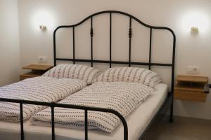 a black bed with white pillows on it at Between Pines&Sea Strunjan in Strunjan