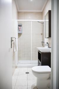 a bathroom with a shower and a toilet and a sink at Casa a 2 minutos a pé de piscina natural in Ponta Delgada +42 photos