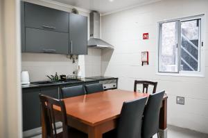 a kitchen with a wooden table and chairs at Casa a 2 minutos a pé de piscina natural in Ponta Delgada