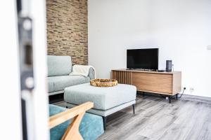 a living room with a couch and a tv at Casa a 2 minutos a pé de piscina natural in Ponta Delgada