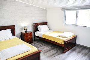 a bedroom with two beds and a window at Casa a 2 minutos a pé de piscina natural in Ponta Delgada