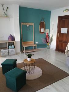 a living room with blue walls and a table and chairs at Apartamento La Bella Vista ATBA00361 in Zafra
