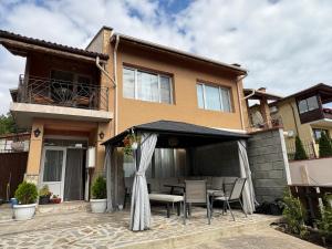 a house with a table and chairs in front of it at Casa Di Pafcho - Balchik Villa Retreat in Balchik