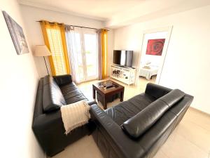 a living room with a black leather couch and a table at Heavenly Homes Mojacar 73 in Mojácar