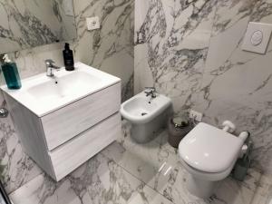 a white bathroom with a sink and a toilet at B&B Mary House con vasca idromassaggio al centro di Salerno in Salerno