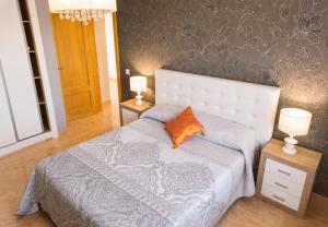 a bedroom with a bed with an orange pillow on it at VILLA MIRAMAR in Peniscola