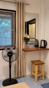 a fan in a room with a window and a table at Secret Place Hotel and Restaurant in Haad Yao