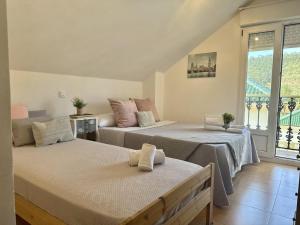 two beds in a room with a window at Chalet Amarena 20812 in Argoños