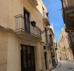 a man standing on a street next to a building at B&B Mirabella Rooms Ortigia in Syracuse
