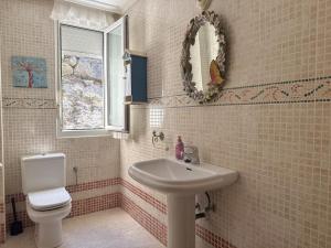 a bathroom with a sink and a toilet and a window at Chalet Amarena 20812 in Argoños +5 photos