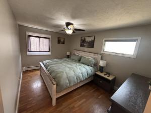 a bedroom with a bed and a ceiling fan at Trailside Lake Retreat in Gaylord