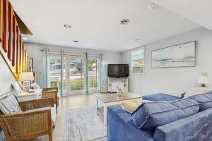 a living room with a blue couch and a tv at Long Sands Escape in York