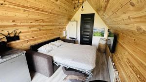 a bed in a small room with wooden walls at Tiny A-Frame Cabin with Private Hot Tub & Views - Perfect for 2 in Şelari