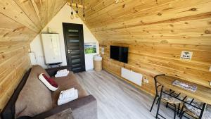 a living room with a couch and a table at Tiny A-Frame Cabin with Private Hot Tub & Views - Perfect for 2 in Şelari