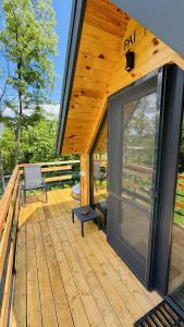 a cabin with a large glass door on a deck at Tiny A-Frame Cabin with Private Hot Tub & Views - Perfect for 2 in Şelari
