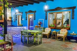 a room with a table and chairs and a blue wall at Resedinta Rotundu in Butuceni