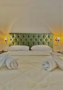 sypialnia z dużym białym łóżkiem z ręcznikami w obiekcie Pink Pineapple Hostel w Atenach