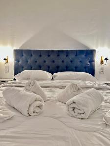 białe łóżko z ręcznikami na nim w obiekcie Pink Pineapple Hostel w Atenach