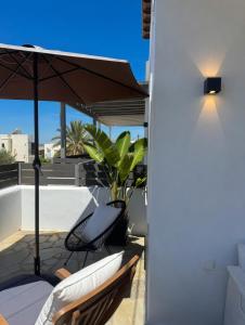 a patio with two chairs and an umbrella at Ovio II in Kampos Paros