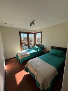 a bedroom with two beds and a window at Global residencial in Rancagua