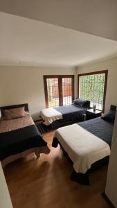 a bedroom with three beds and two windows at Global residencial in Rancagua