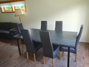 a dining room table with four chairs and a couch at Hus Gryllefjord in Gryllefjord