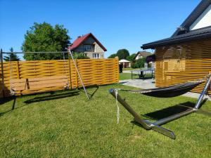 a hammock in a yard next to a wooden fence at Domek na Dogalu in Filipowice