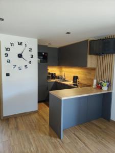 a kitchen with a large clock on the wall at Domek na Dogalu in Filipowice