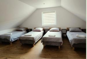 a attic room with four beds and a window at Domek na Dogalu in Filipowice +17 photos