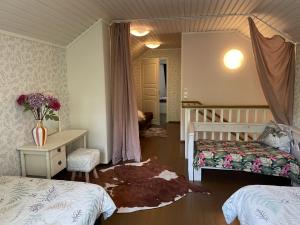 a bedroom with two beds and a table and a desk at Koivuniemen Ranch in Hämeenlinna