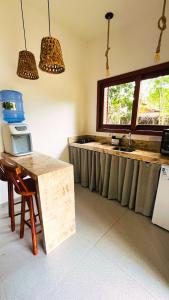 a kitchen with a counter with a sink and a window at Casa Miava - Studio 1 - Cozy place a few meters from the beach in Marau