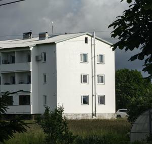 a white building with a car in front of it at Mõnus peatuspaik Saaremaa põhjaranniku avastamiseks in Myustelʼ