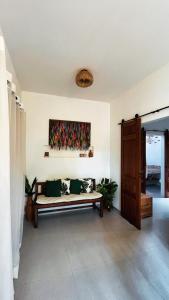 a living room with a couch and a painting on the wall at Casa Miava - Studio 1 - Cozy place a few meters from the beach in Marau