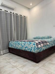 a bed sitting in a room with curtains at Central Residence & Conciergerie Ouaga 2000 in Ouagadougou