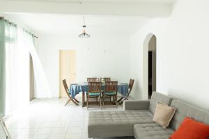 a living room with a couch and a table at Bas de villa 3 chambres - Jardin privé - 20 minutes aéroport in Baie-Mahault