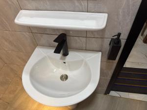 a white toilet with a sink in a bathroom at Central Residence & Conciergerie Ouaga 2000 in Ouagadougou +37 photos