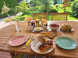 a wooden table with plates of food on it at L'estrade des Alpes 45m2 petit-déjeuner inclus in Saint-Alban-de-Roche
