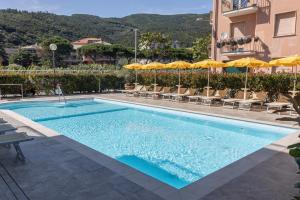 a swimming pool with chairs and umbrellas next to a building at Hotel Riviera in Deiva Marina