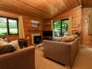 a living room with two couches and a fireplace at Derwent Lodge in Keswick