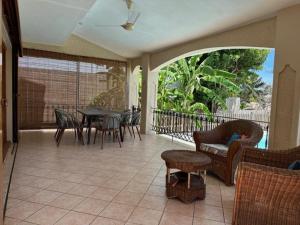a screened in porch with a table and chairs at Dodo Casita House in Tamarin
