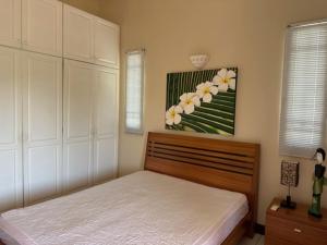 a bedroom with a bed and a painting of flowers at Dodo Casita House in Tamarin
