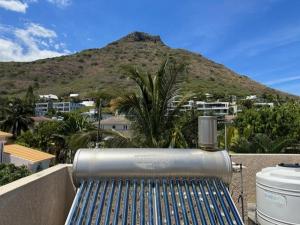 a bench on a balcony with a mountain in the background at Dodo Casita House in Tamarin